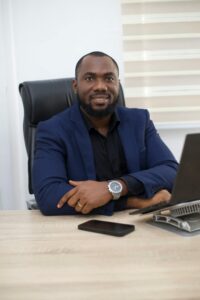 Confident African businessman in formal attire working at desk in modern office.