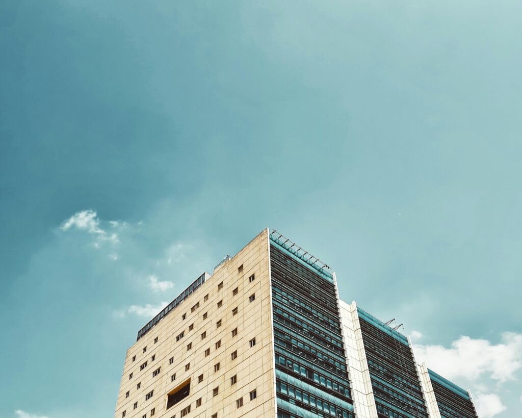 Tall modern office building with clear blue sky, showcasing urban architecture and minimalist design.